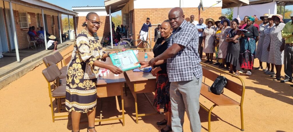 Imelda handing over medica equipment to the District Development Coordinator and District Nursing Officer 2 1
